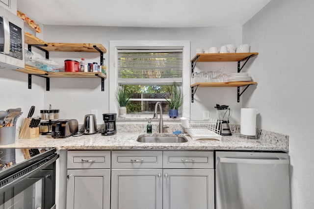 interior space with open shelves, light stone countertops, appliances with stainless steel finishes, and a sink