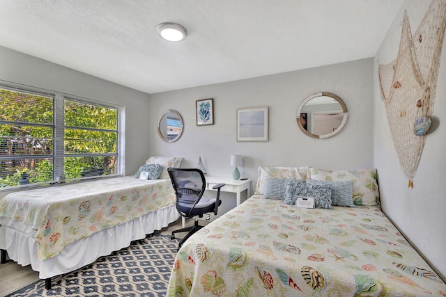 bedroom with wood finished floors and a textured ceiling