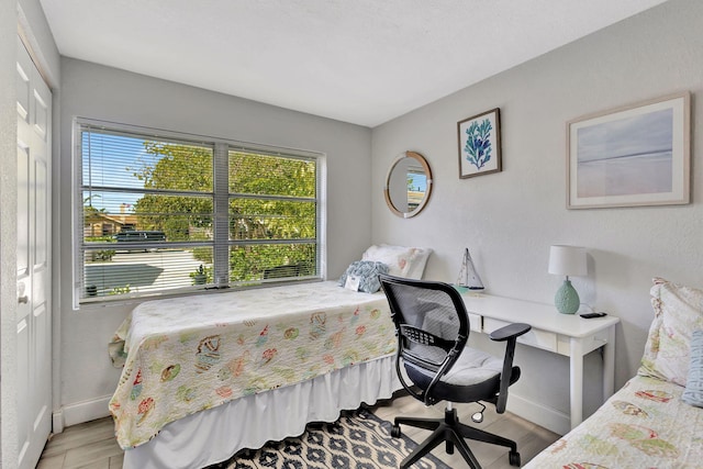 bedroom with wood finished floors and baseboards