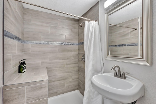 full bathroom with a tile shower and a sink