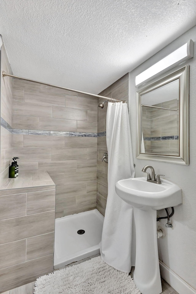 full bath featuring a shower stall and a textured ceiling