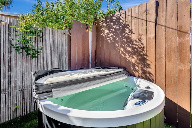 exterior space featuring fence and a hot tub