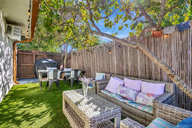 view of patio with a wall mounted air conditioner, an outdoor hangout area, area for grilling, and a fenced backyard