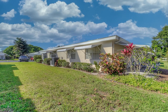 exterior space featuring stucco siding and a yard