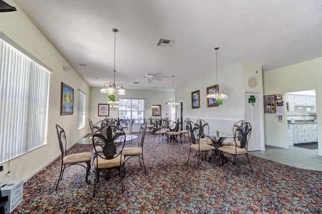 dining room with ceiling fan with notable chandelier, visible vents, and a textured ceiling