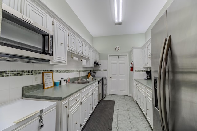 kitchen featuring white cabinetry, decorative backsplash, appliances with stainless steel finishes, and a sink