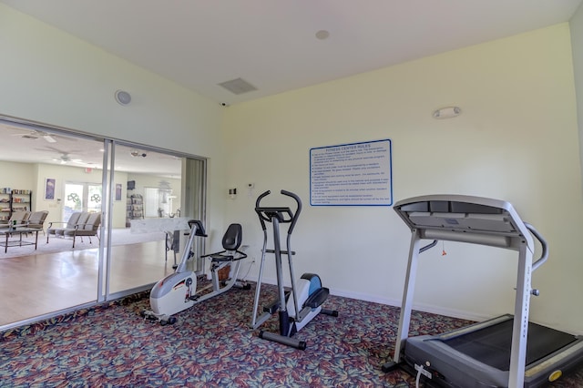 exercise area featuring baseboards, a ceiling fan, and carpet floors