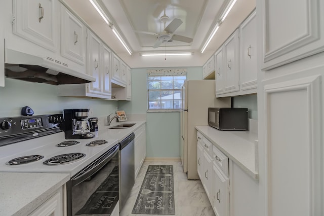 kitchen featuring black microwave, under cabinet range hood, a tray ceiling, electric stove, and a sink