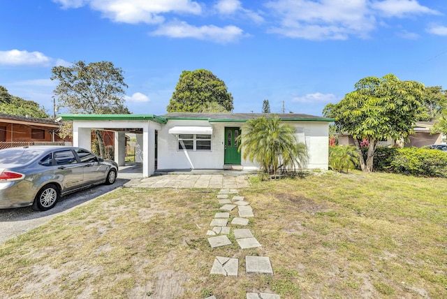 view of front of property with a carport and a front lawn