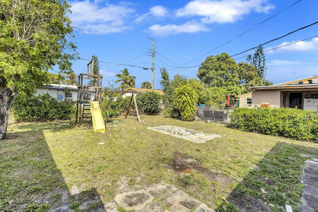 view of yard with fence and a playground