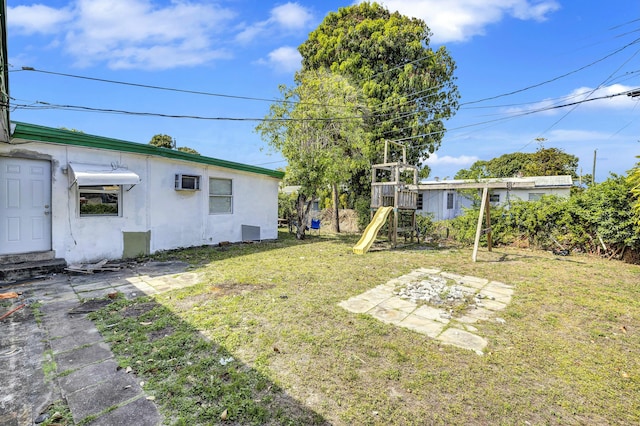 view of yard with an AC wall unit and a playground