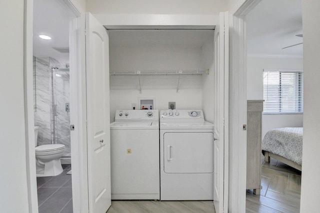 laundry area with washer and dryer, light wood-type flooring, ornamental molding, and laundry area