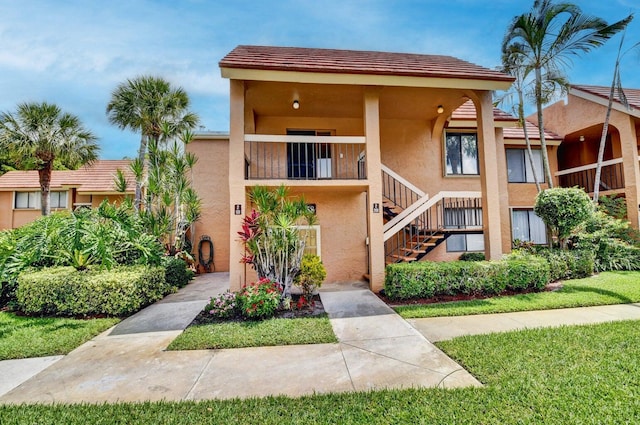 view of front of property with stairs and stucco siding