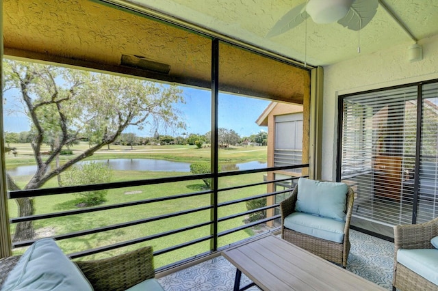 sunroom with a water view and ceiling fan