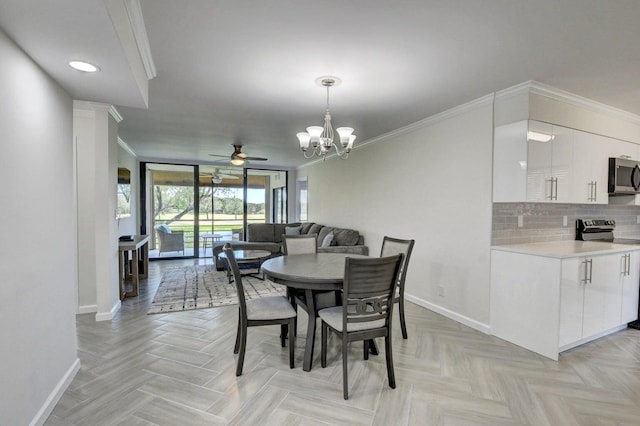 dining space featuring baseboards, ornamental molding, and ceiling fan with notable chandelier