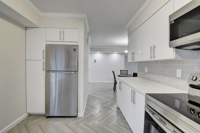 kitchen with tasteful backsplash, white cabinetry, appliances with stainless steel finishes, crown molding, and light countertops