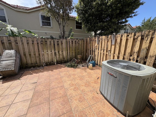 view of patio featuring central AC unit and fence