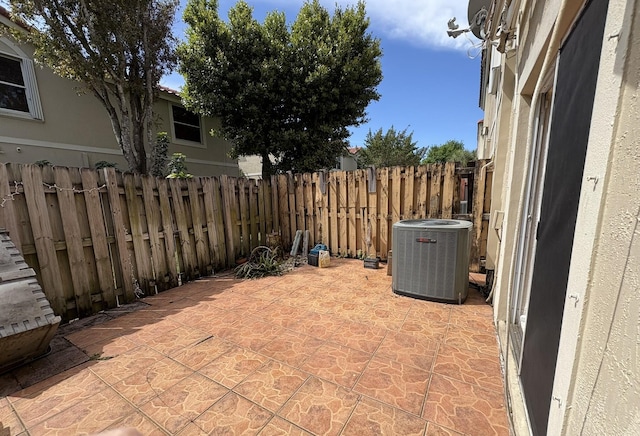 view of patio / terrace featuring central air condition unit and fence