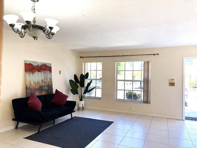 interior space with an inviting chandelier, baseboards, tile patterned floors, and a textured ceiling