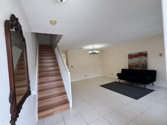 stairs with tile patterned floors, baseboards, a textured ceiling, and an inviting chandelier