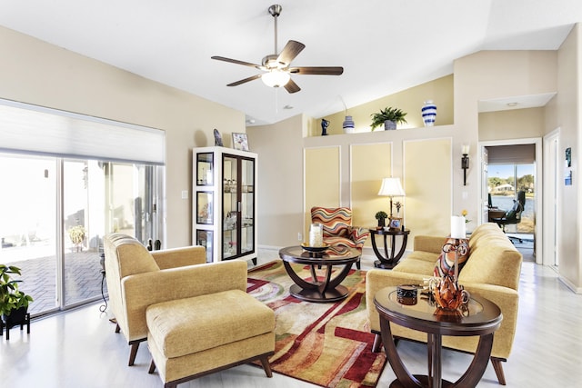 living room with a ceiling fan, a healthy amount of sunlight, light wood-type flooring, and high vaulted ceiling