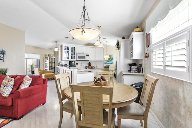 dining area with ceiling fan and light wood-style floors