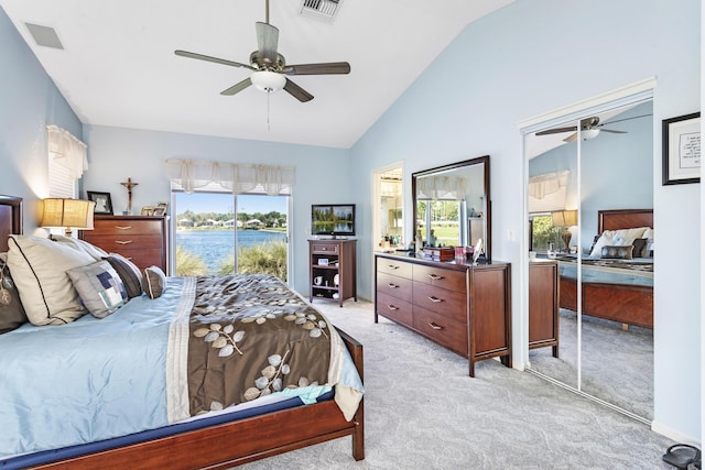 bedroom featuring vaulted ceiling, visible vents, light colored carpet, and multiple windows