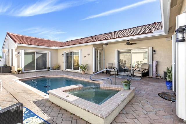 rear view of house featuring stucco siding, a tile roof, a ceiling fan, and a patio area