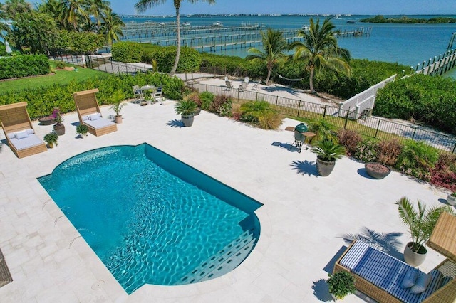 view of swimming pool with a patio, fence, a water view, and a water slide