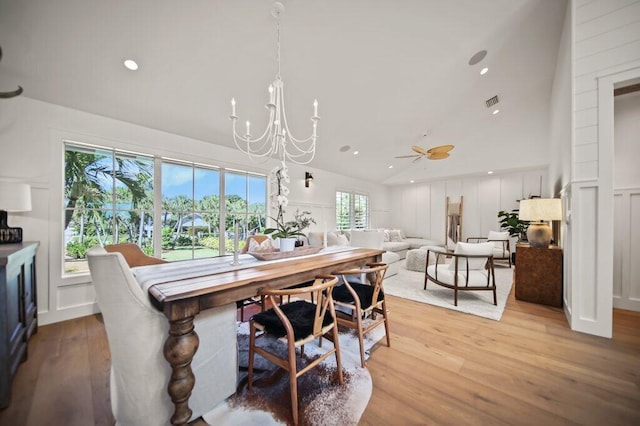 dining space featuring recessed lighting, light wood-style floors, a chandelier, and a decorative wall