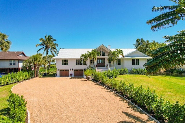 view of front of property featuring a front lawn, a garage, and driveway