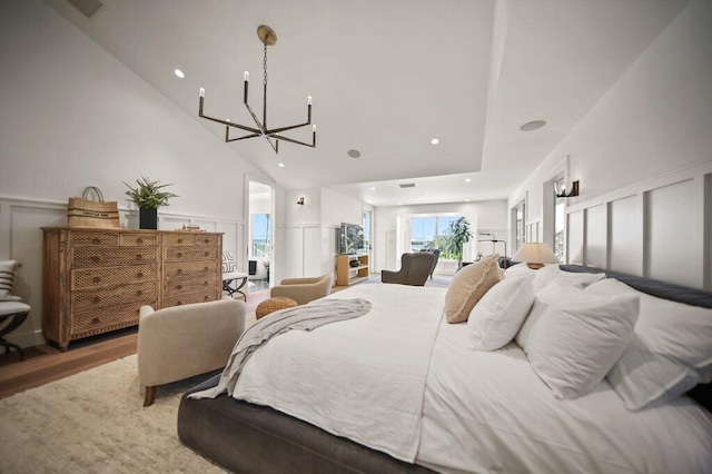 bedroom featuring a chandelier, recessed lighting, wood finished floors, a decorative wall, and access to outside