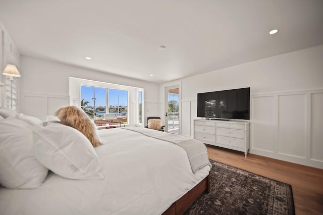 bedroom with wood finished floors, a wainscoted wall, recessed lighting, access to exterior, and a decorative wall