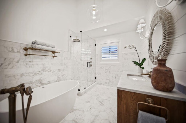 bathroom featuring vanity, a stall shower, a freestanding bath, tile walls, and marble finish floor