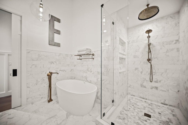 full bathroom with a freestanding tub, marble finish floor, a wainscoted wall, and a tile shower