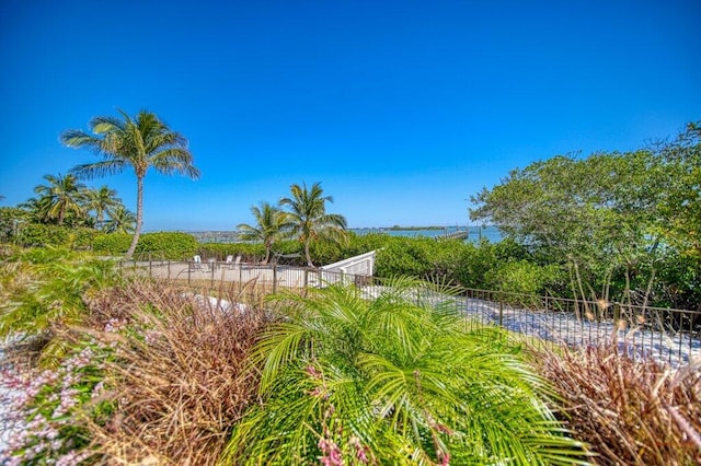 view of property's community featuring a water view and fence