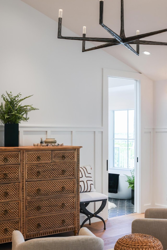 room details featuring a decorative wall, recessed lighting, wood finished floors, and wainscoting