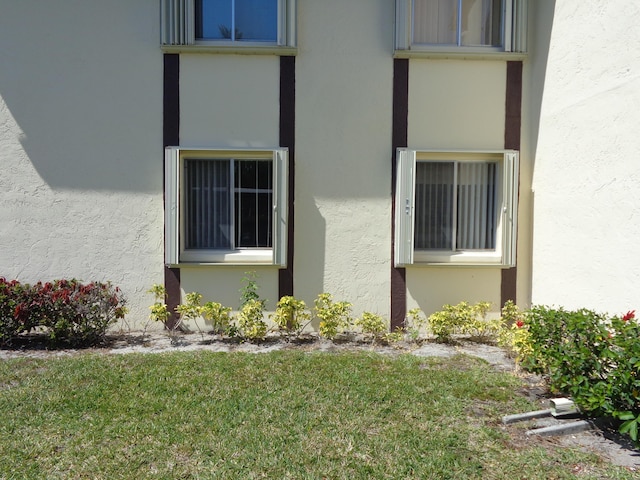 view of home's exterior featuring stucco siding and a yard