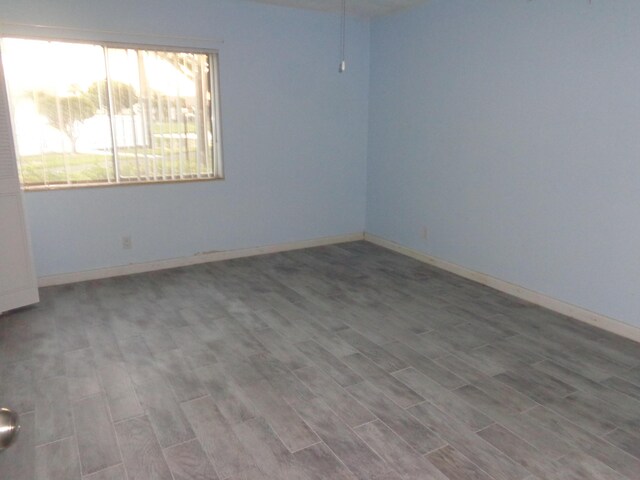 empty room with baseboards and wood finished floors