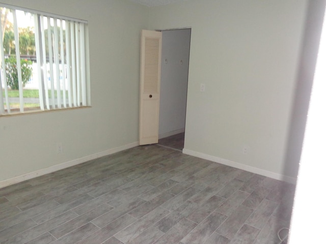 empty room with baseboards and wood tiled floor