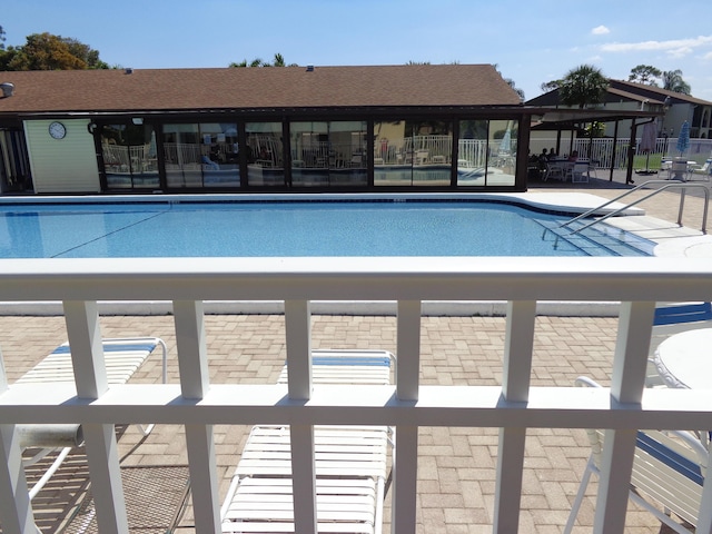 community pool with fence and a patio area