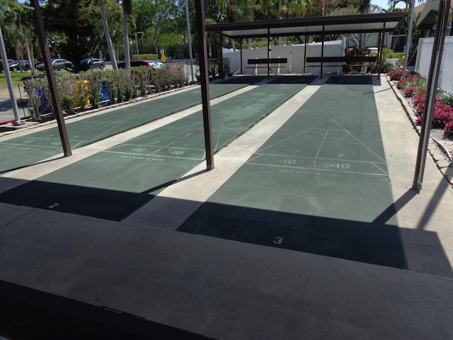 view of property's community featuring shuffleboard and fence