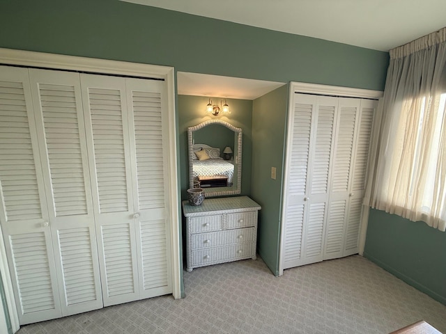 unfurnished bedroom featuring carpet and multiple closets