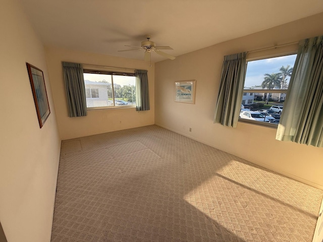 carpeted empty room with a ceiling fan