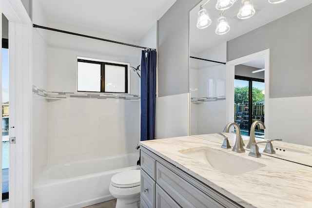 bathroom featuring shower / bath combination with curtain, toilet, and vanity