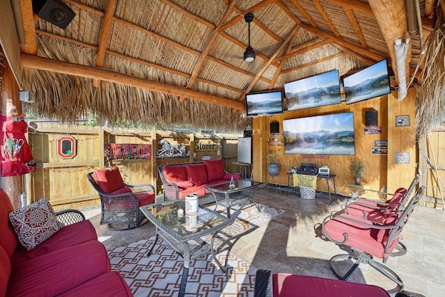 living area featuring wooden walls and high vaulted ceiling