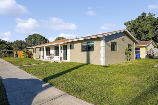 ranch-style house featuring stucco siding and a front lawn