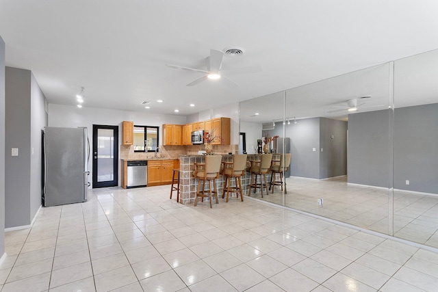 kitchen with light tile patterned floors, stainless steel appliances, visible vents, and a ceiling fan