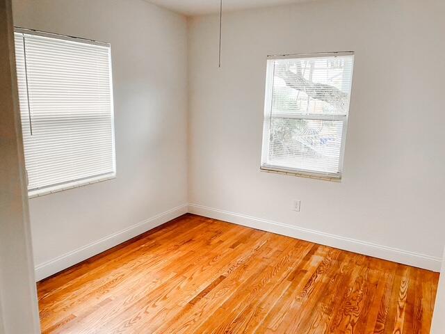 spare room with light wood finished floors and baseboards