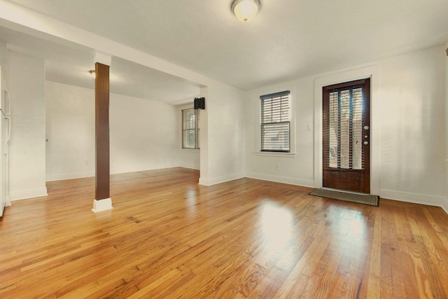 entrance foyer with baseboards and light wood finished floors